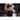 Athlete applies chalk on hands in a gym, preparing for lifting weights.