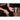 Hands apply liquid chalk indoors, seated near a wooden surface.